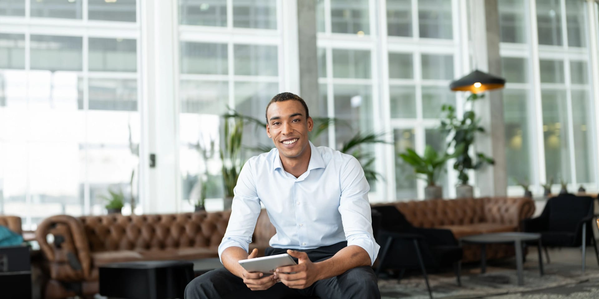 An employee sits with an iPad in the café at Uniper's headquarters in Düsseldorf.