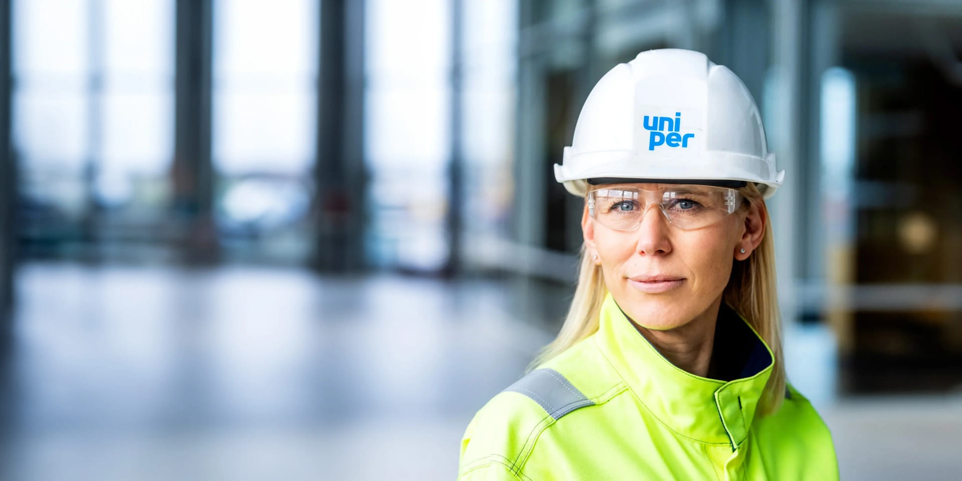 Eine Mitarbeiterin steht mit Helm und Sicherheitskleidung in einem Uniper Kraftwerk in Schweden.