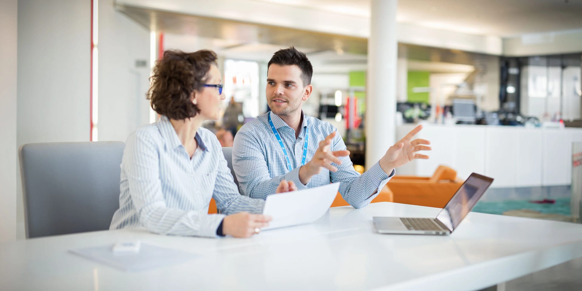 An employee and a colleague with a laptop in a meeting situation in the office.
