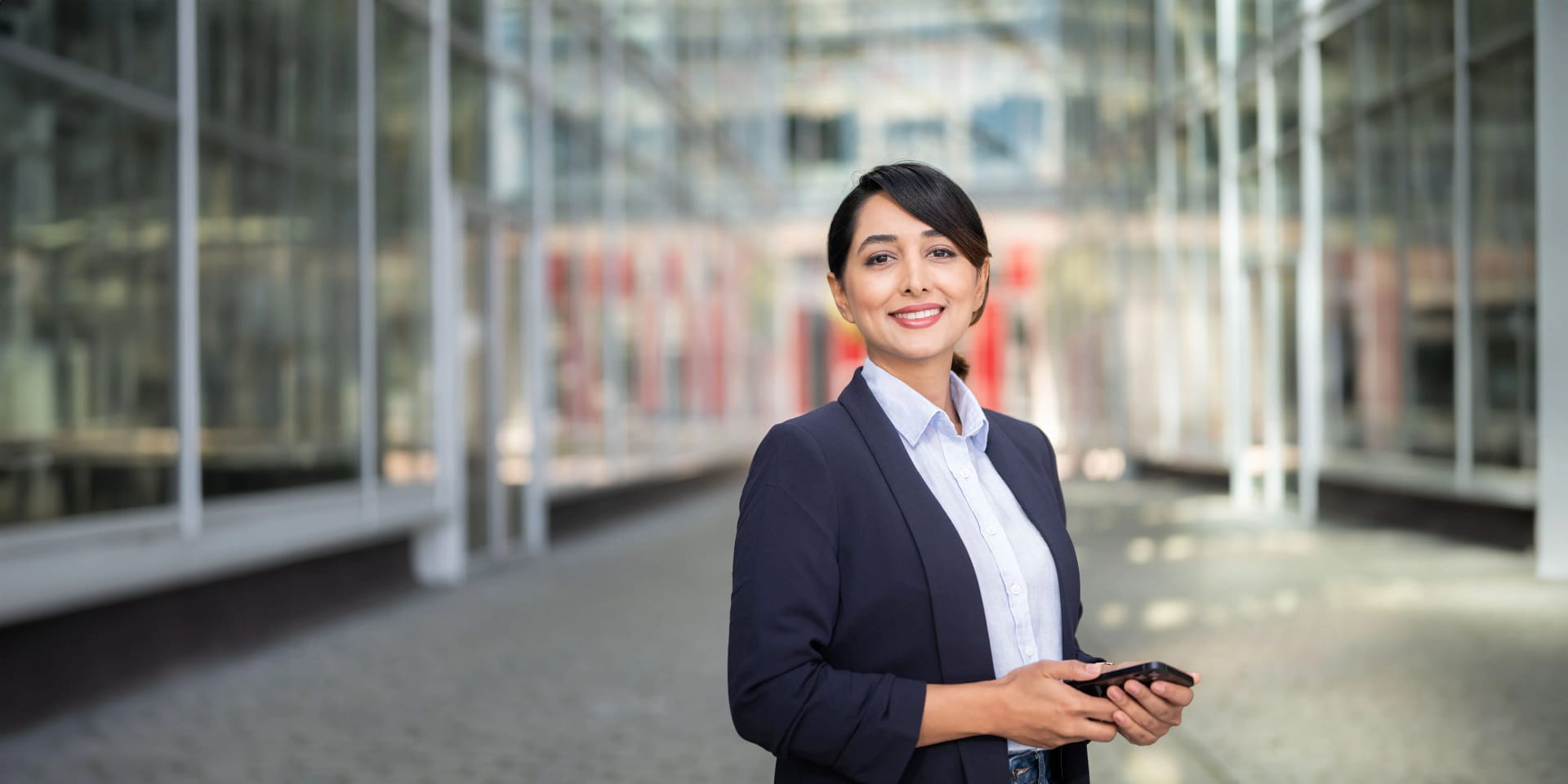 Eine Mitarbeiterin steht vor dem Glasgebäude des Uniper Hauptstandortes in Düsseldorf.